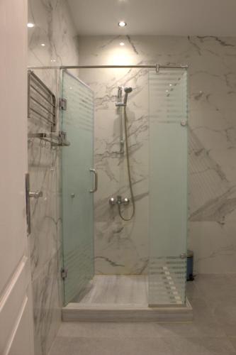 une salle de bain avec une douche avec une porte vitrée dans l'établissement Fully equipped studio Sahl Hasheesh, à Hurghada