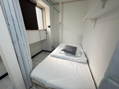 Ένα ή περισσότερα κρεβάτια σε δωμάτιο στο Osaka Guesthouse Sakura