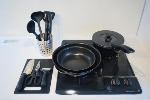 a black tea pot on a black tray with utensils at Metro Gate by Tranova in Tokyo
