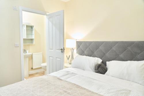 a white bedroom with a large bed and a bathroom at F&Fs in Nuneaton