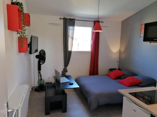 une petite chambre avec un lit et une fenêtre dans l'établissement La Sweet House Rouge* Au pied des remparts *wifi*, à Avignon