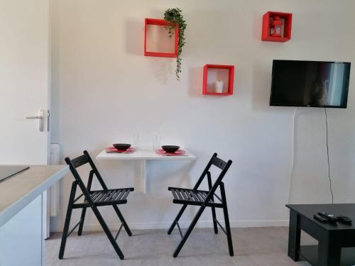 Il comprend une cuisine avec 2 chaises et une table avec une télévision. dans l'établissement La Sweet House Rouge* Au pied des remparts *wifi*, à Avignon