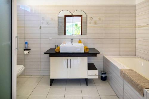 a bathroom with a sink and a mirror and a tub at Villa COIN DE MIRE, 4 chambres avec piscine privée à Bain Boeuf in Bain Boeuf