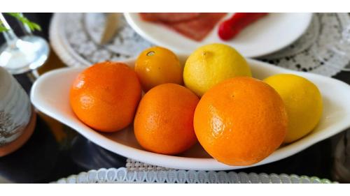 a bowl of oranges and lemons on a table at The Bungalow in Ormoc