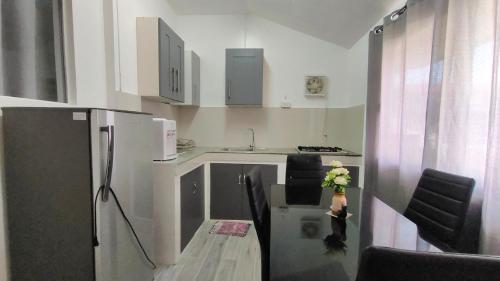 a kitchen with a refrigerator and a table with a vase of flowers at The Bungalow in Ormoc