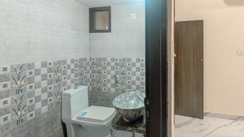 a bathroom with a toilet and a sink at Cozy Stays by The Pink Nest in Jaipur