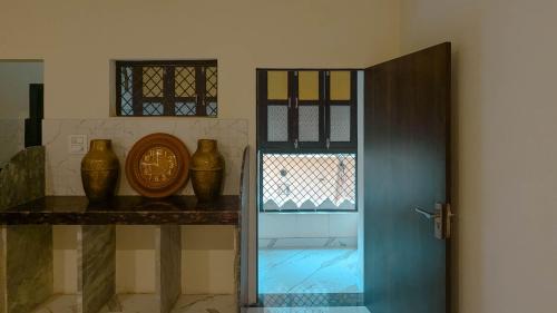a room with a door and some vases on a shelf at Cozy Stays by The Pink Nest in Jaipur