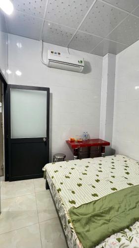 a bedroom with a bed and a table with a table at HOMESTAY Hoàng GIa in Ấp Ông Tú