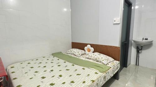 a bedroom with a bed with a teddy bear on it at HOMESTAY Hoàng GIa in Ấp Ông Tú