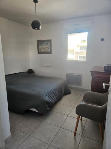 une chambre avec un lit, une chaise et une fenêtre dans l'établissement Attitude 43, à La Ciotat
