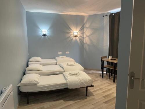 3 lits dans une chambre avec une table et des lumières dans l'établissement Résidences saint pierre, à Lourdes