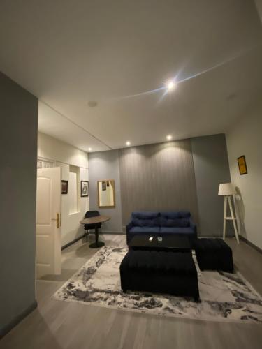 a bedroom with a blue bed and a table at Hotel Swan Suites in Lahore