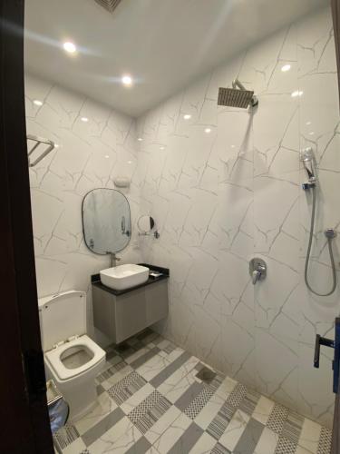 a bathroom with a toilet and a shower at Hotel Swan Suites in Lahore