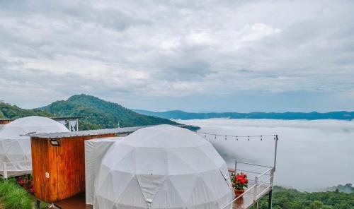 two white domes on a roof with a view of a lake at ชิวชิวแคมป์ ภูชี้ฟ้า in Ban Huai Han