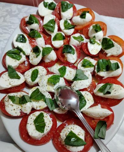 a plate of food with tomatoes and a spoon at Hotel Sporting in Casarsa della Delizia