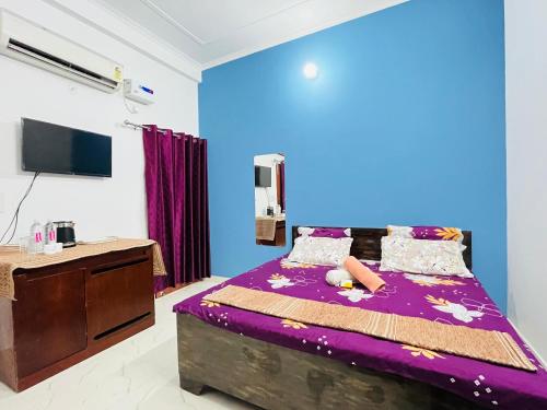 una camera con letto viola e parete blu di Maa vaishno paying guest house a Ayodhya