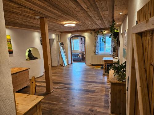 a room with a hallway with a wooden ceiling and a table at Premium Apartment mit privatem Whirlpool, Sauna, Garten in Sankt Martin am Grimming