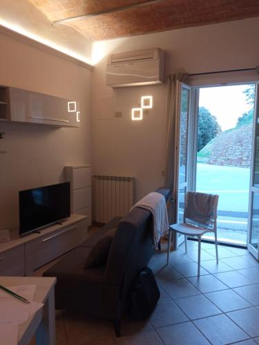 a living room with a couch and a tv and a window at La Dodicesima Luna in Peccioli