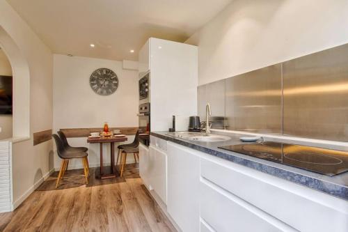 a kitchen with a counter and a table with chairs at Petite maison place du marché in Deauville