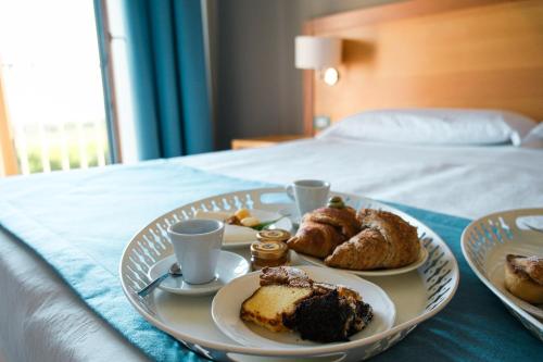 a tray of food on a bed with a plate of food at Hotel Scoglio Degli Achei in Torre Santa Sabina