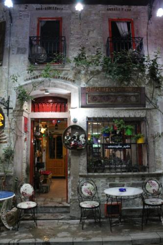 a building with tables and chairs in front of a building at şekercigiller in Ayvalık