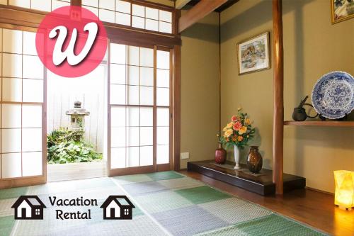 a room with a large window and a vase of flowers at -W- Vacation Rental in Nagoya