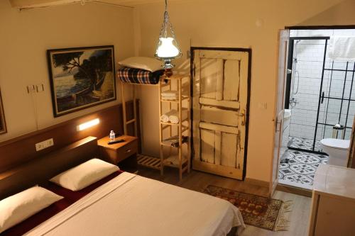 a bedroom with a bed and a door to a bathroom at şekercigiller in Ayvalık