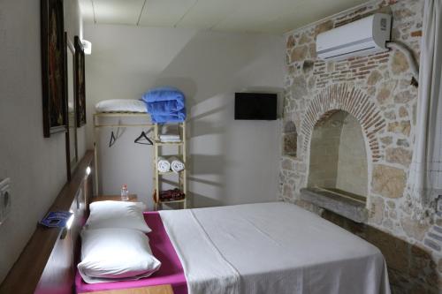 a room with a bed and a stone wall at şekercigiller in Ayvalık