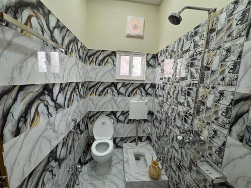 a bathroom with a toilet and black and white tiles at Metro One Hotel in Lahore