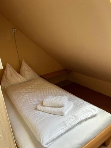 a bed with white sheets and pillows on it at Haus Peter in Murau