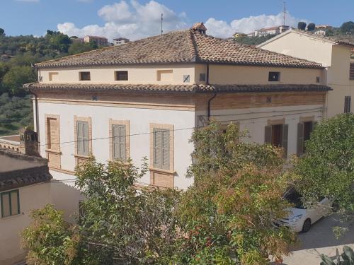 a white house with a car parked in front of it at Casa Pilato in Loreto Aprutino