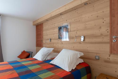 - une chambre avec un lit et un mur en bois dans l'établissement Chalet Rochebrune - Apartment La Turche, aux Gets