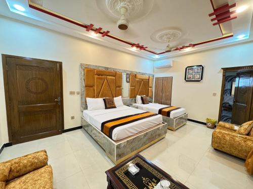 a bedroom with two beds and a couch at Metro One Hotel in Lahore