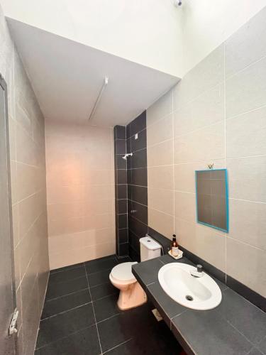 a bathroom with a toilet and a sink at Homestay Seri Iskandar By Ummi in Seri Iskandar
