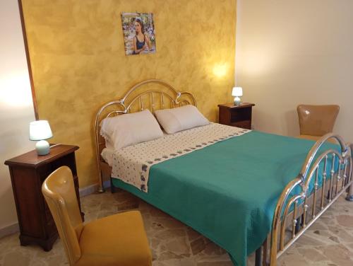 1 dormitorio con 1 cama con manta verde y 2 sillas en Apartament di Nick Central Station, en Palermo