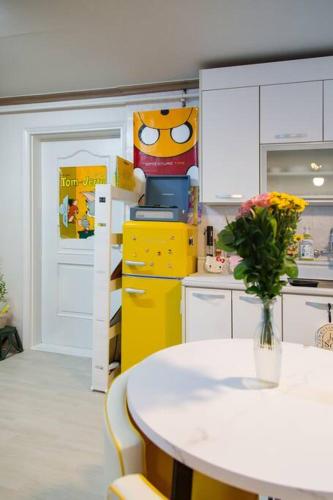 a kitchen with a table with a vase of flowers at Anime House in Daejeon