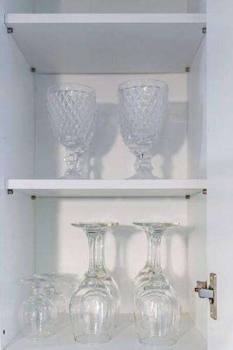 four wine glasses sitting on a white shelf at Anime House in Daejeon