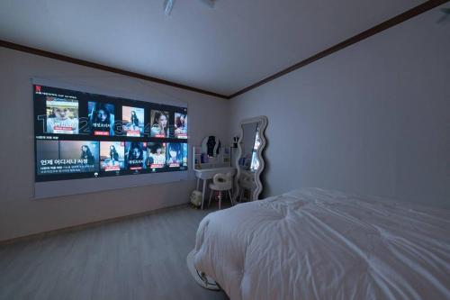 a bedroom with a bed and a large screen television at Anime House in Daejeon