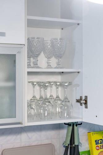 a row of wine glasses on a shelf in a kitchen at Anime House in Daejeon
