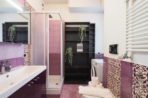 a bathroom with a sink and a shower with purple tiles at Primopiano - Bonghi B in Milan