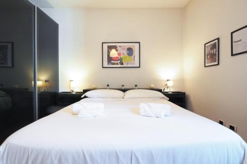 a bedroom with a large white bed with two pillows at Primopiano - Bonghi B in Milan