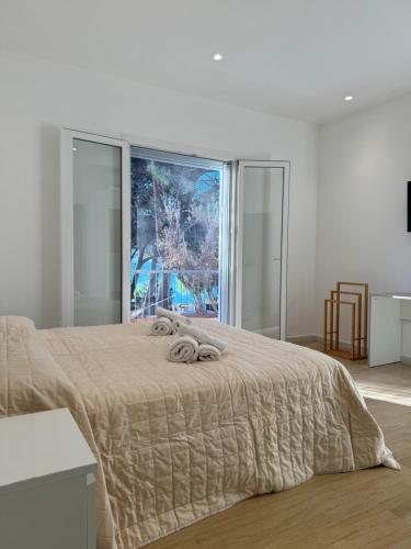 a bedroom with a large bed with a large window at Casa cancello a mare in Santa Flavia