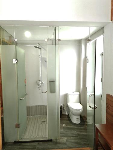 a bathroom with a glass shower and a toilet at Zhangjiajie Forest Park Youth Hostel in Zhangjiajie