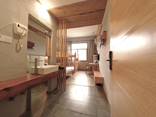 a bathroom with a sink and a mirror at Zhangjiajie Forest Park Youth Hostel in Zhangjiajie