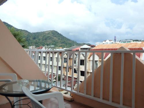 a balcony with a glass table and a view of a city at Boomerang Inn in Patong Beach