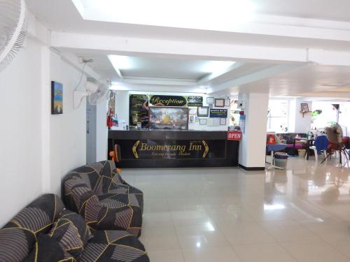 a lobby with chairs and a bar in the middle at Boomerang Inn in Patong Beach