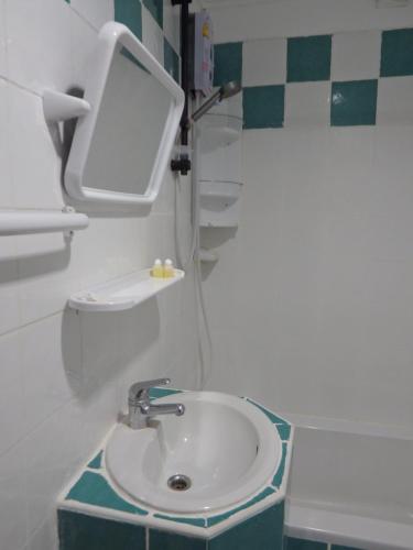 a small bathroom with a sink and a mirror at Boomerang Inn in Patong Beach
