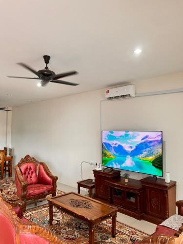 a living room with a flat screen tv on a wall at Homestay Seri Iskandar By Ummi in Seri Iskandar