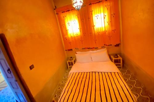 a small bed in a small room with a window at Nomadic Birdway in Imiter