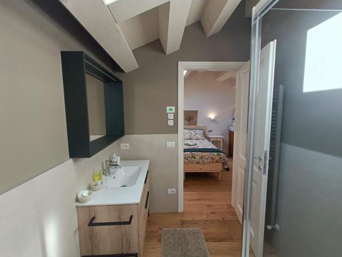 a bathroom with a sink and a bedroom with a bed at B&B Annalisa in Segusino